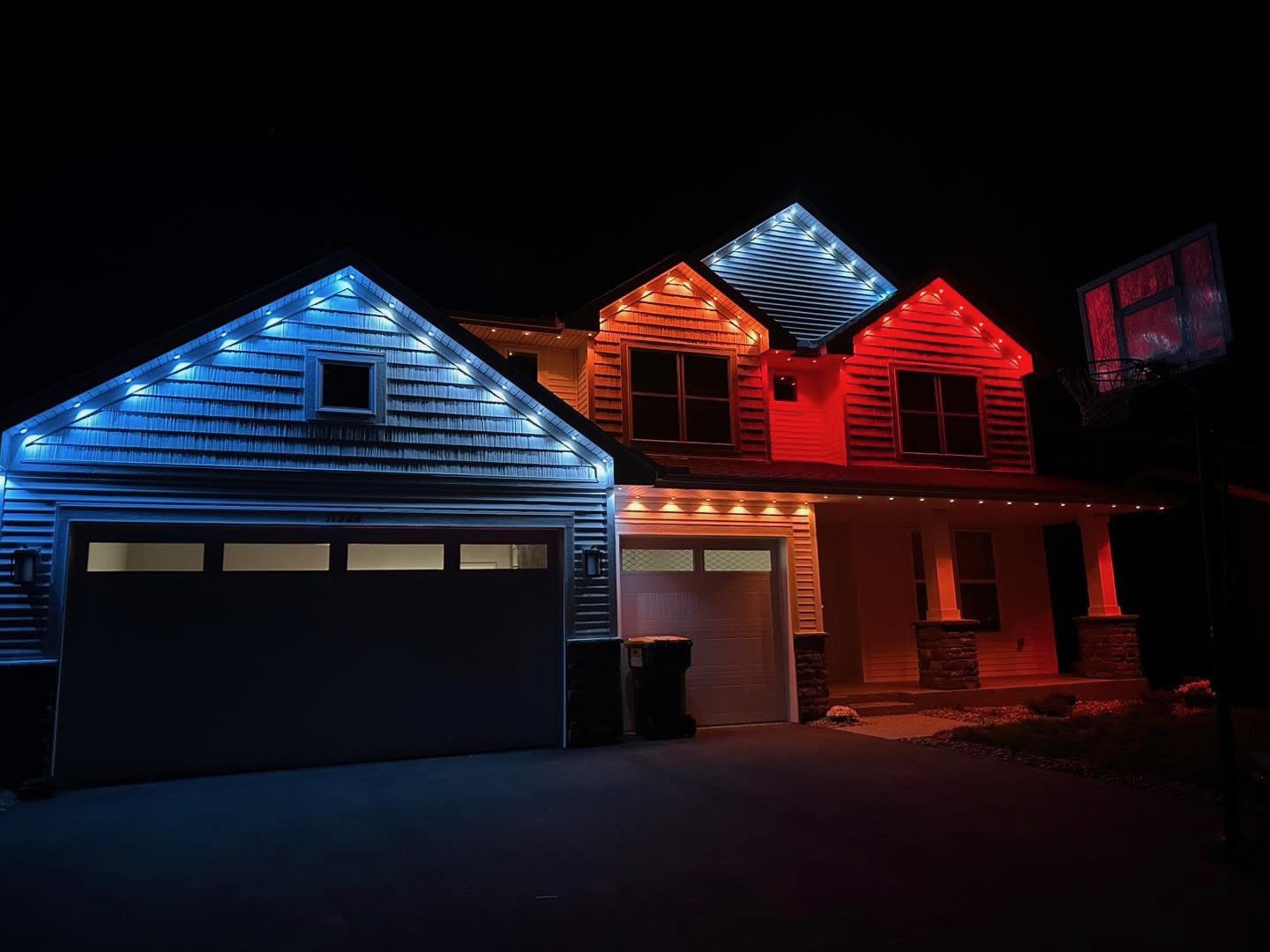 Home gables lit in blue, warm white and red permanent LED lights