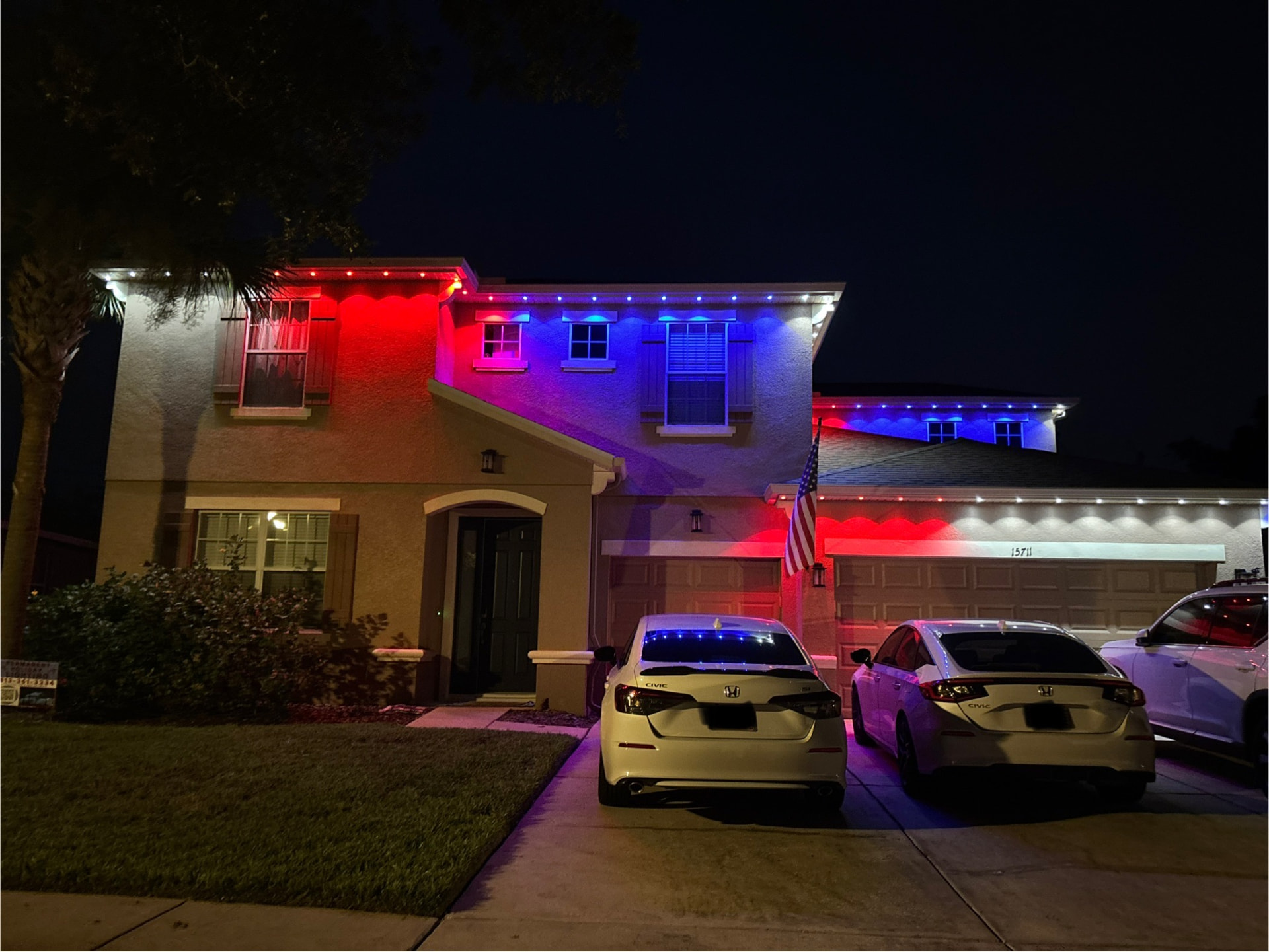 Two-story home with red, white and blue permanent LED roofline lighting